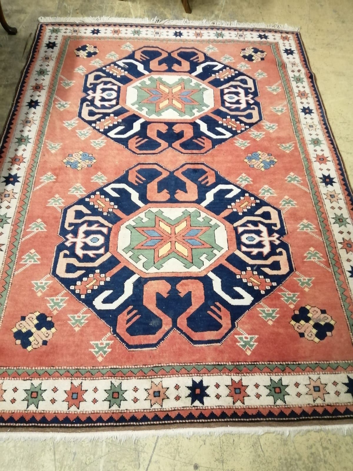 A peach ground rug centred by two stylised foliate blue ground medallions, 230 x 170cm